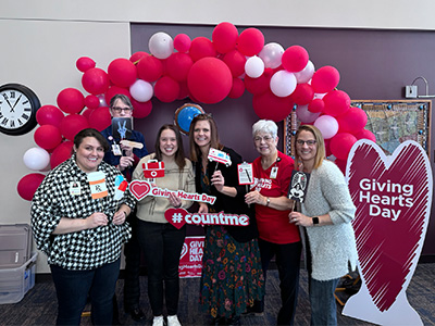 Group celebrating under balloon arch