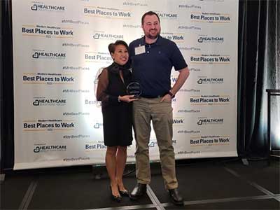 Registered Nurse Chris Freeman accepts JRMC's Best Places to Work award.