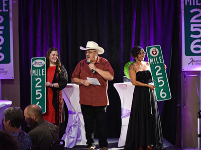 Image of Nenow Auction auctioning off Mile Marker 256 signs at the Journey to Mile 256 cancer fundraiser.