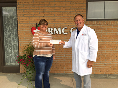 Image of JRMC Orthopedic Surgeon, Dr. Michael T. Dean, presenting donation to Carrington Daily Bread representative.