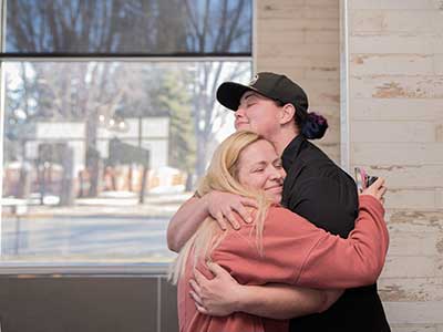 image of Kristin Brehm hugging Melissa Burdick