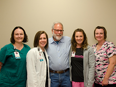 Image of JRMC Wound Center staff with patient, Kirk Ohlheiser, after he received HBOT treatment to reduce his bladder hemorrhage.