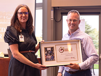 JRMC Foundation Director Lisa Jackson awards Jamestown Middle School Principal Mark Stillwell the Outstanding Seedling award for youth philanthropy.