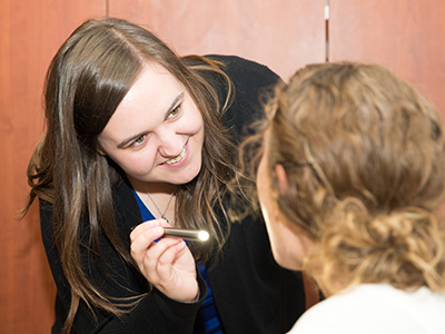 Image of JRMC Speech Language Pathologist, Lauren Burningham, examining a patient.